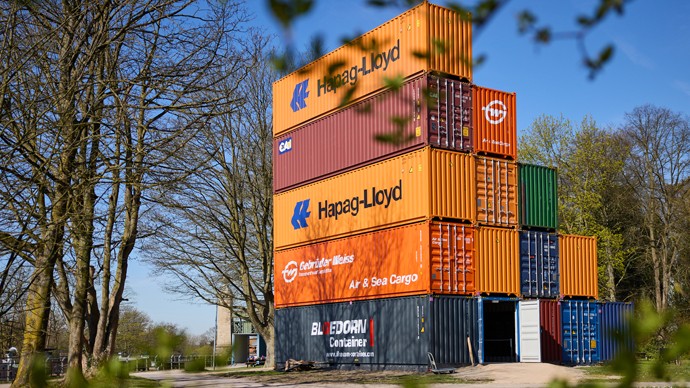 Fünfstöckiges Gebäude aus 15 Containern in unterschiedlichen Farben. Fünfstöckiges Gebäude aus 15 Containern in unterschiedlichen Farben.